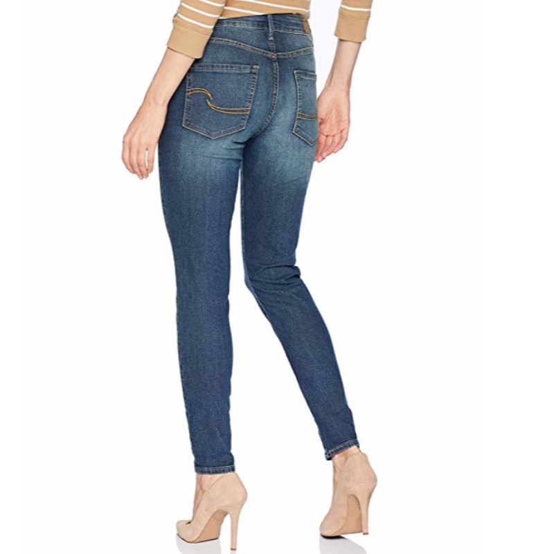 As calças de brim skinny modernas das mulheres da etiqueta do ouro