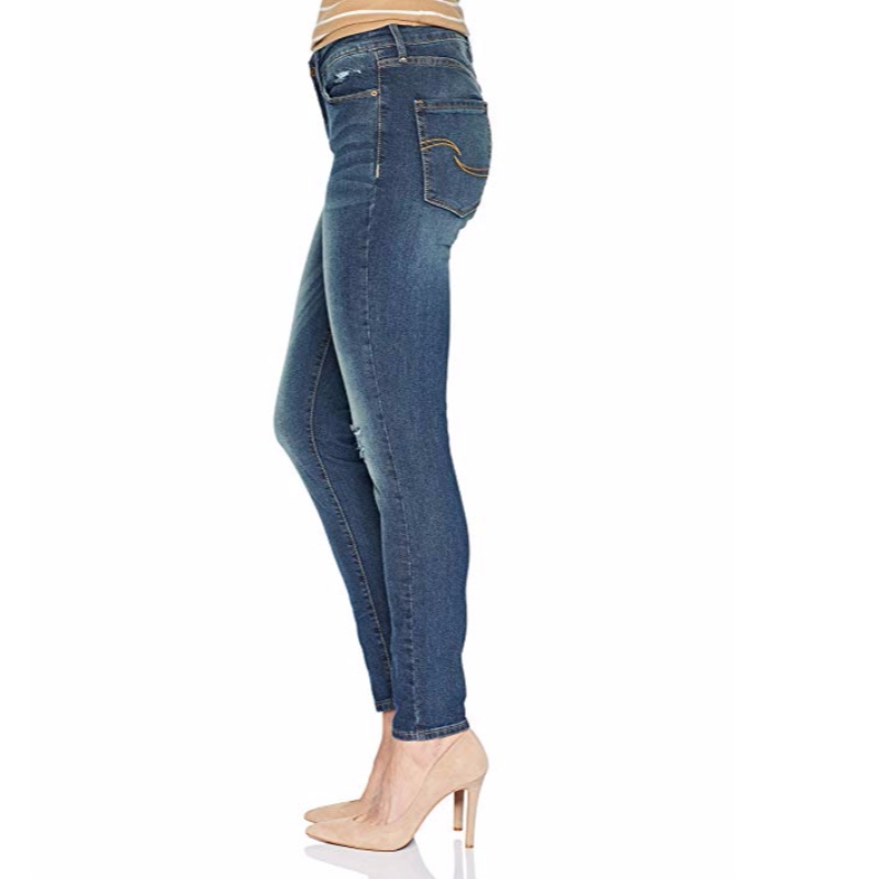 As calças de brim skinny modernas das mulheres da etiqueta do ouro